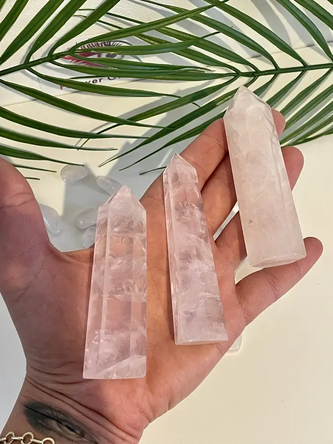 Rose quartz point medium, held in the hand