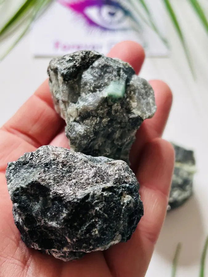 Emerald roughstone, held in the hand