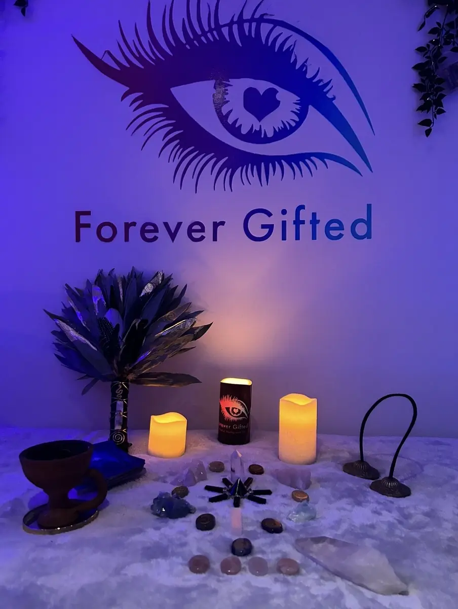 Filiz's altar in the cabin with candles, crystals and a feather