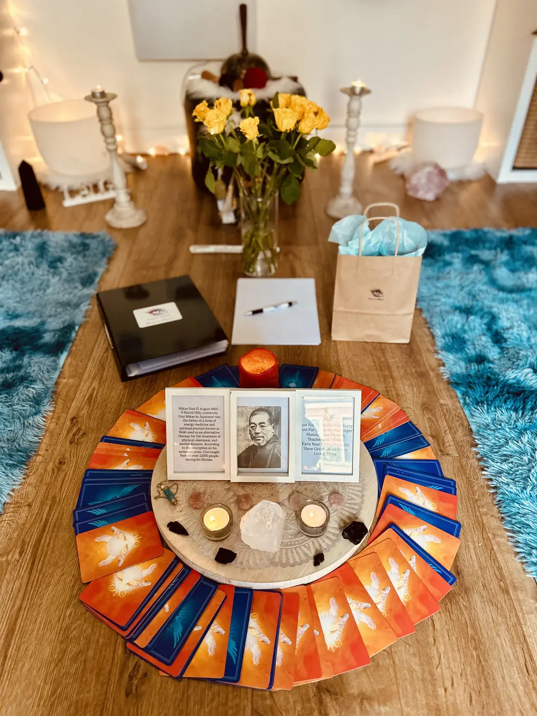Reiki course table set with certificates, a Holy Fire manual, a portrait of Mikao Usui and oracle cards