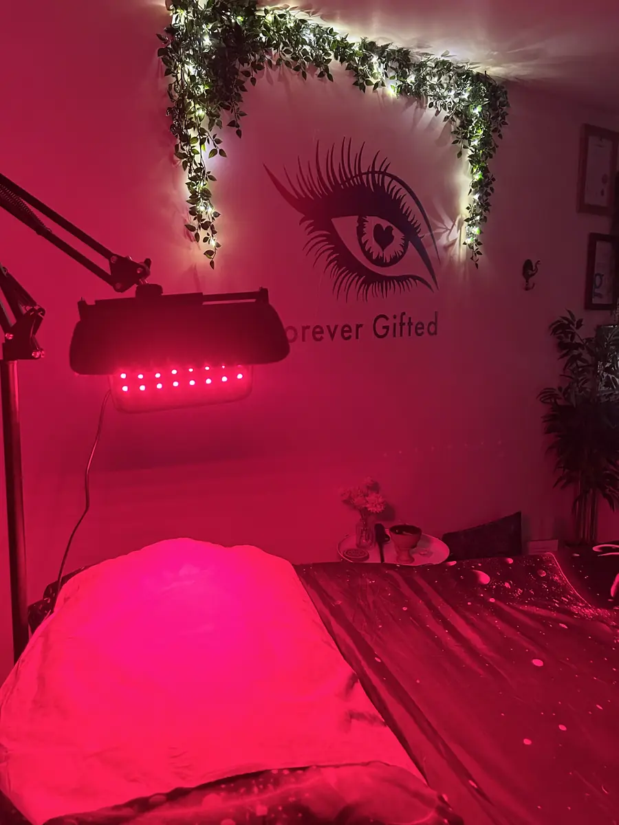 The treatment bed glowing under the red light panel